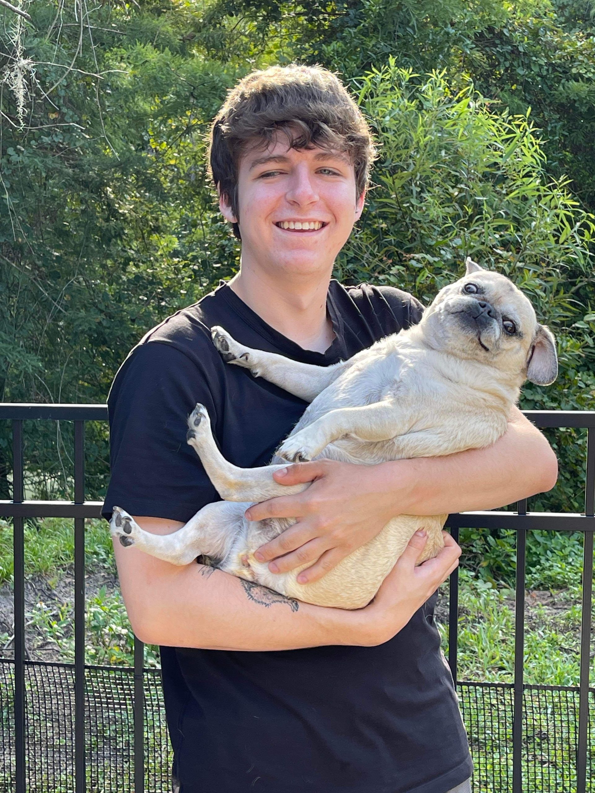 jaxon holding his pug luna outside